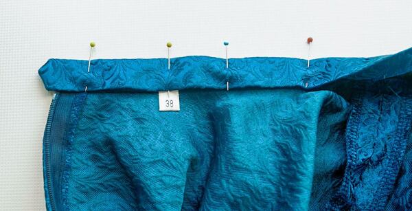 Pinning down the waistband. This is a good time to add size or brand tags. How to make a circle skirt – pinning down the waistband