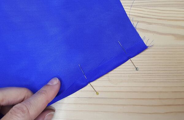 Press the edge – For this type of hem, add a generous half inch (roughly 1.5 cm) on each side. Start with two opposite sides; fold the edge towards the back 3/8 inch (1 cm) and iron. How to make a silk scarf